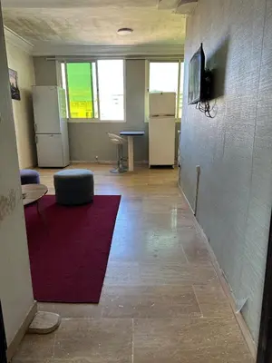 an office hallway with a red rug and a room with a refrigerator at Studio cosy et abordable in Casablanca