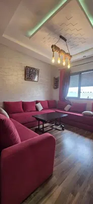 a living room with red couches and a table at appartement luxe dt3 in Mohammedia