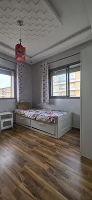 a bedroom with a bed and two windows at appartement luxe dt3 in Mohammedia