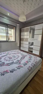 a bedroom with a bed with a white and red bedspread at appartement luxe dt3 in Mohammedia