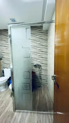 a bathroom with a shower with a door and a toilet at appartement calme dt4 in Mohammedia