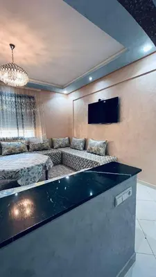 a large living room with a couch and a tv at appartement calme dt4 in Mohammedia