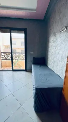 a bedroom with a bed and a large window at appartement calme dt4 in Mohammedia