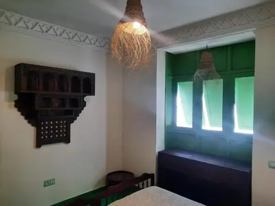 a dining room with a window and a chandelier at Casitademama in Sidi Yahia az Zaʼer