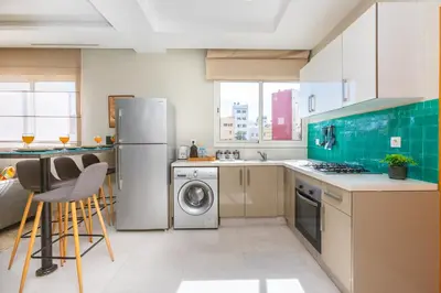 a kitchen with a refrigerator and a dishwasher at Seafront 2BR AC Sunny Corniche in Casablanca