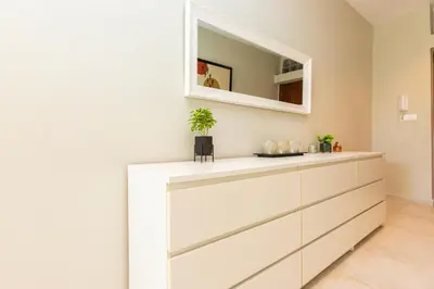 a kitchen with white cabinets and a mirror at Seafront 2BR AC Sunny Corniche in Casablanca