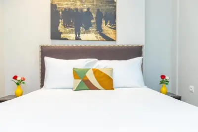 a white bed with a colorful pillow on it at Seafront 2BR AC Sunny Corniche in Casablanca