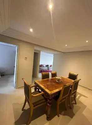 a dining room with a wooden table and chairs at Beach 1 min walk Pool Elevator Carrefour in O Ben Slimane