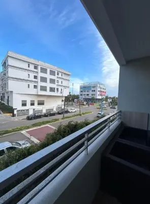 a balcony with a view of a street and buildings at Beach 1 min walk Pool Elevator Carrefour in O Ben Slimane