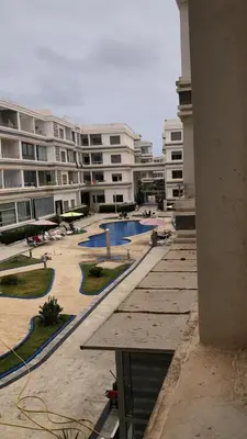 a view of an apartment complex with a swimming pool at Beach 1 min walk Pool Elevator Carrefour in O Ben Slimane