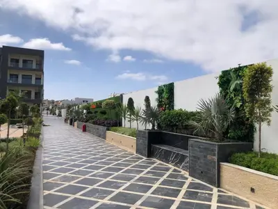 a sidewalk with plants on the side of a building at 3 bedrooms in El Mansouria with pool beach terrace in Pont Blondin