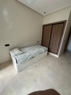 a bedroom with a bed and a wooden door at 3 bedrooms in El Mansouria with pool beach terrace in Pont Blondin
