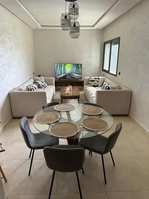 a living room with a table and chairs and a couch at 3 bedrooms in El Mansouria with pool beach terrace in Pont Blondin