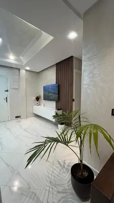 a living room with a potted plant on the floor at Appartement Moderne et Lumineux in Rabat