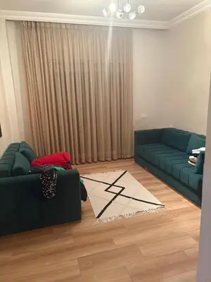 a living room with a green couch and a rug at Nice apartment with terrace overlooking pool in O Ben Slimane