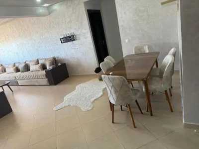 a living room with a table and chairs and a couch at Modern apartment in Rabat, Temara in Temara
