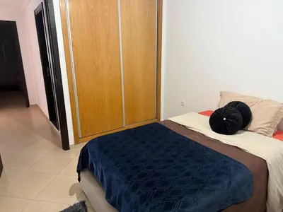 a bed with a black pillow sitting on top of it at Modern apartment in Rabat, Temara in Temara
