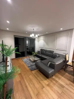 a living room with a black leather couch and wooden floors at Stunning Marina high floor ocean view in Casablanca