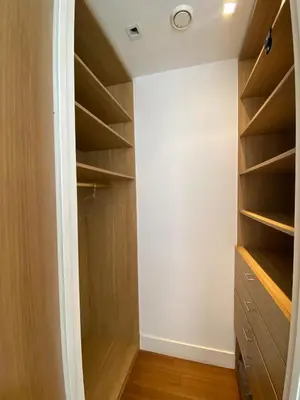 a walk in closet with wooden shelves at Pearl Of Eden Island in Bouznika