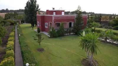 a small red house with a yard with a house at Le refuge vert in Berrechid