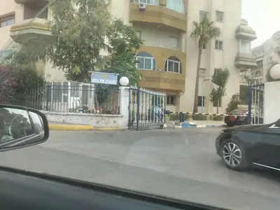 a car parked in front of a building with a fence at Calme large studio in Casablanca