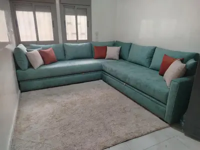 a green couch with pillows on it in a living room at Calme large studio in Casablanca