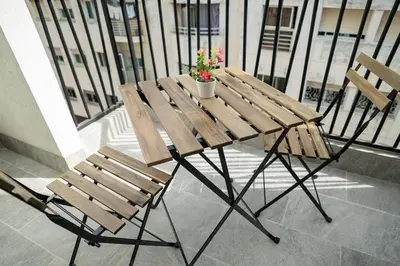 a wooden table with two chairs and a potted plant on a balcony at CFC Modern Studio Emplacement Face à Anfa Park in Casablanca