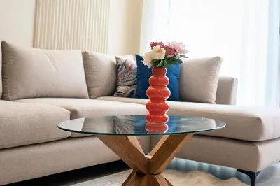 a red vase on a glass table in front of a couch at CFC Modern Studio Emplacement Face à Anfa Park in Casablanca