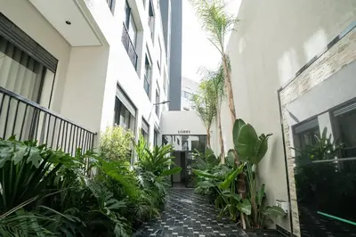 a courtyard of a building with plants and a walkway at CFC Modern Studio Emplacement Face à Anfa Park in Casablanca