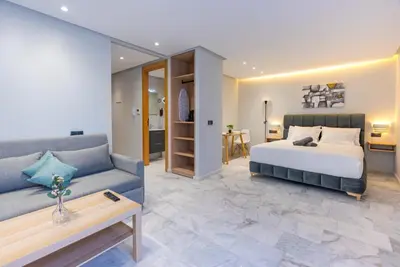 a bedroom with a bed and a couch at Faya Nova- Appart hotel Central Stay in Casablanca