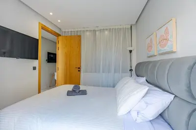 a bedroom with a large white bed with a pillow at Faya Nova- Appart hotel Central Stay in Casablanca