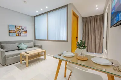a living room with a table and a couch at Faya Nova- Appart hotel Central Stay in Casablanca