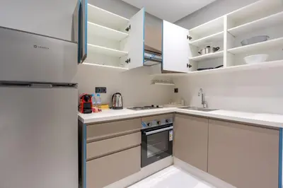 a kitchen with white cabinets and a refrigerator at Faya Nova- Appart hotel Central Stay in Casablanca