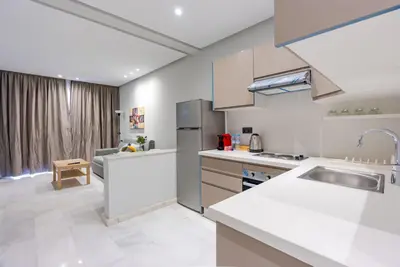 a kitchen with white countertops and a sink at Faya Nova- Appart hotel Central Stay in Casablanca