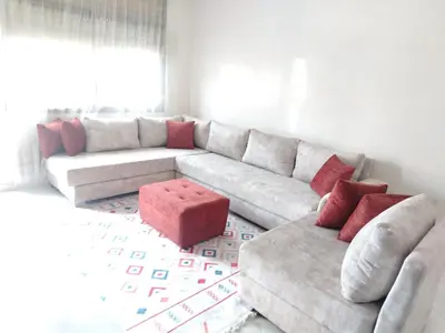 a living room with a white couch and red pillows at Très joli appartement à Casablanca in Casablanca