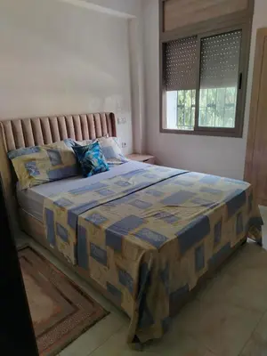 a bedroom with a bed with a blue and yellow quilt at Très joli appartement à Casablanca in Casablanca