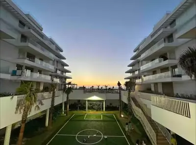 a tennis court in front of a apartment building at L' Evasion BLeu au Carroussel in Rabat