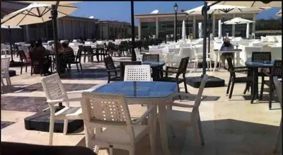 an outdoor patio with tables and chairs and umbrellas at Lovely three sides Appart in Ola Blanca in Sidi Rahal