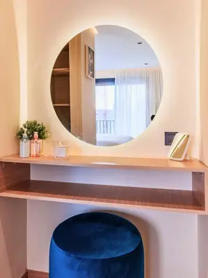 a round mirror on a shelf with a blue stool at Appartement Cosy neuf - Salle de sport in Casablanca