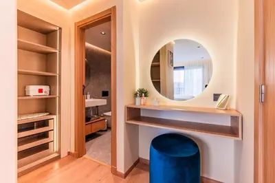 a bathroom with a round mirror and a blue stool at Appartement Cosy neuf - Salle de sport in Casablanca