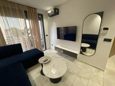 a living room with a blue couch and a mirror at Luxury studio Maarif à 5 min CFC in Casablanca