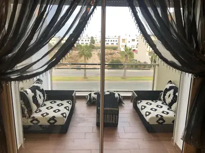 a room with two couches and a large window at Apartment in residence CASABAY in Sidi Rahal
