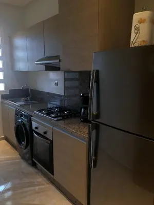 a kitchen with a refrigerator and a stove at Apartment in residence CASABAY in Sidi Rahal