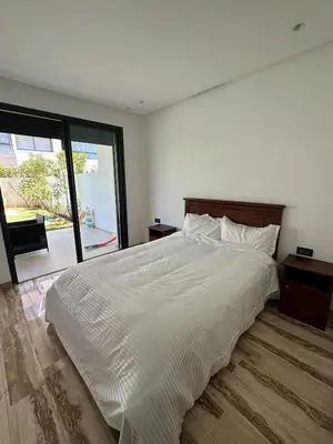 a bedroom with a white bed and a large window at Luxurious Apartment with Serene Garden & Private Pool in Casablanca