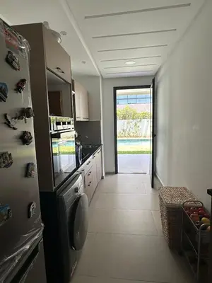 a kitchen with a refrigerator freezer next to a door at Luxurious Apartment with Serene Garden & Private Pool in Casablanca