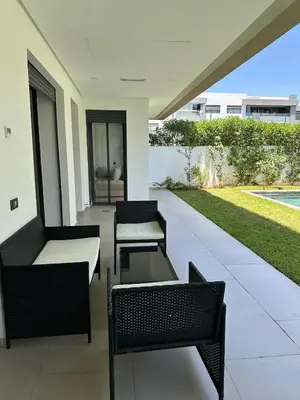 a patio with two chairs and a table at Luxurious Apartment with Serene Garden & Private Pool in Casablanca