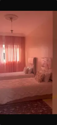 a bedroom with two beds with white sheets and a window at Casa 2mars Appart lumineux in Casablanca