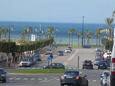 a busy city street with cars parked on the beach at Appartement meuble rabat in Rabat