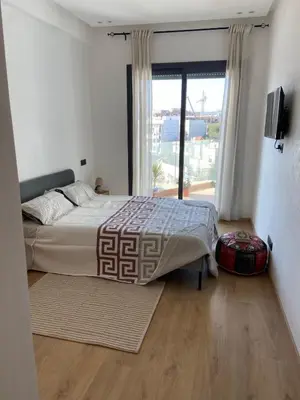 a bedroom with a bed and a large window at Bright & cozy studio in Oasis, close to train station in Casablanca