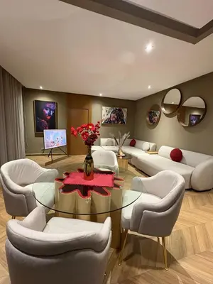 a living room with a glass table and white chairs at Appartement haut standing Casablanca in Casablanca